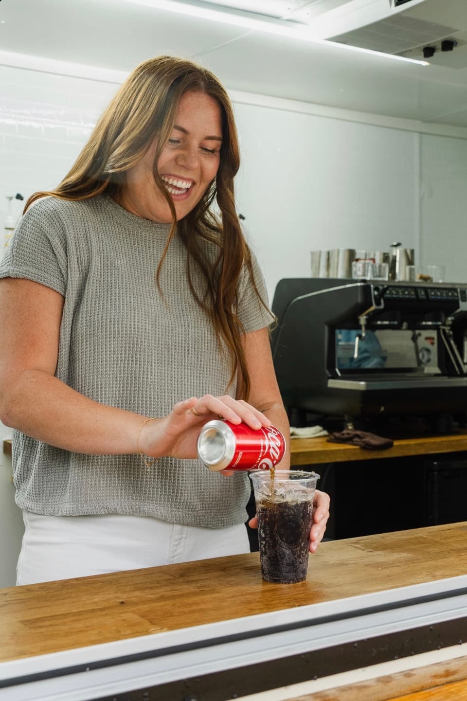 Team member smiling while pouring a dirty soda at the trailer